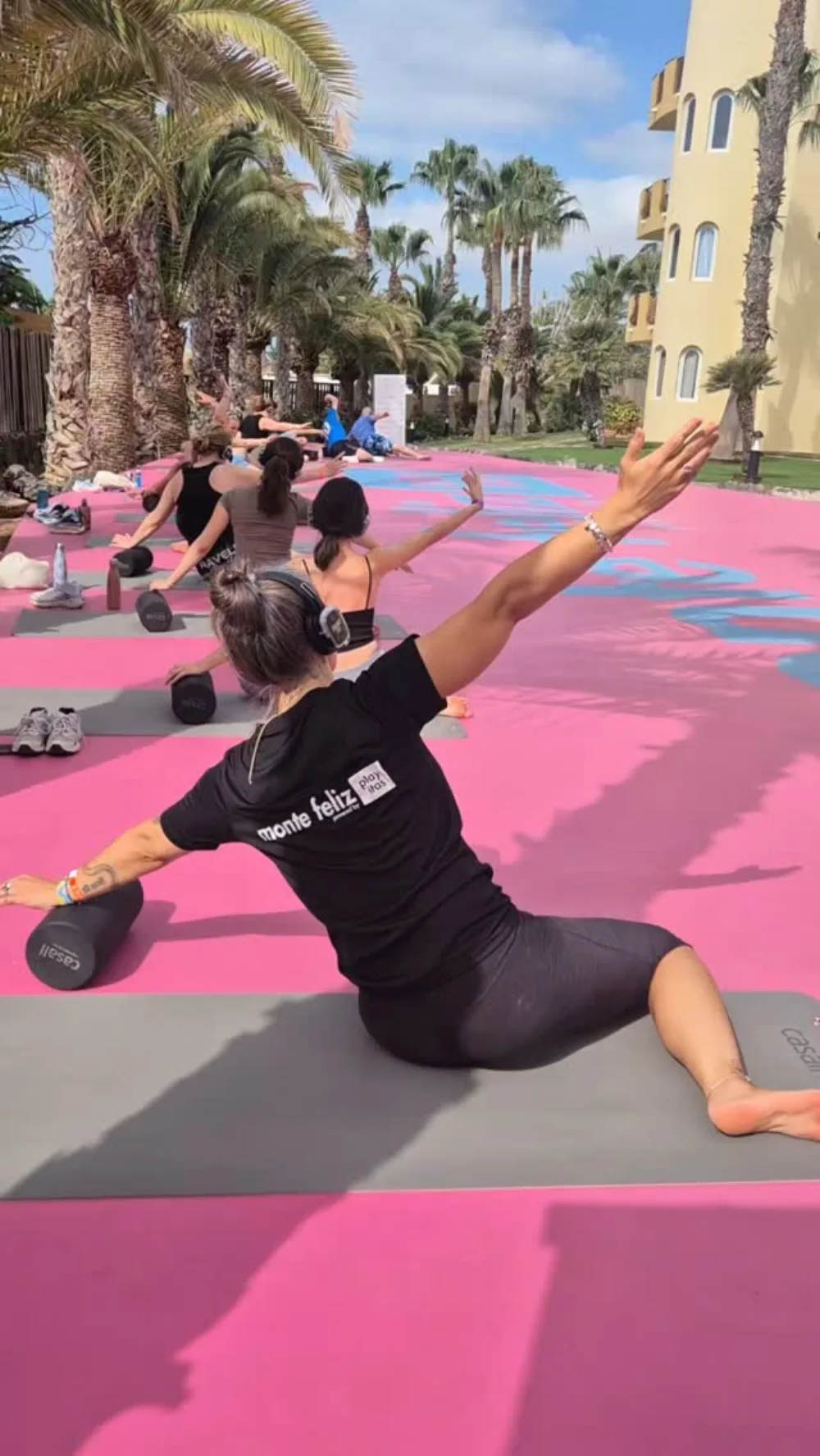 Emma leading an outdoor foam roller class on a pink court