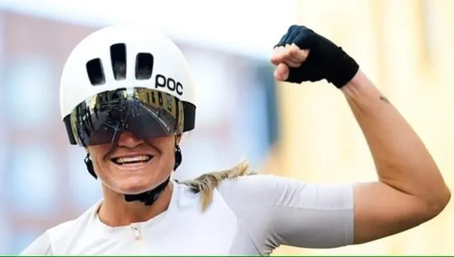 Emma raising her fist in a white POC helmet